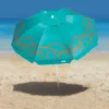 Guarda sol Campeche Verde Turquesa Tobee aberto na areia em frente ao mar com estampa fluida laranja e sombra projetada.