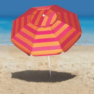 Guarda Sol Aruba Tobee listrado em tons de vermelho e laranja aberto e fixado na areia da praia com o mar ao fundo.