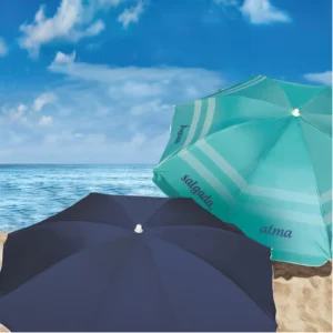 Dois modelos de guarda-sol Tobee Ipanema na praia: versão azul escuro e versão turquesa com a frase estampada, funcionando como sombreiro moderno e ombrelone de praia