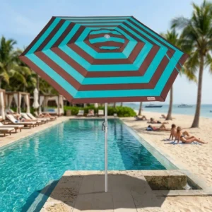 Guarda-sol ombrelone Malibu Tobee em destaque à beira da piscina com uma praia paradisíaca ao fundo.