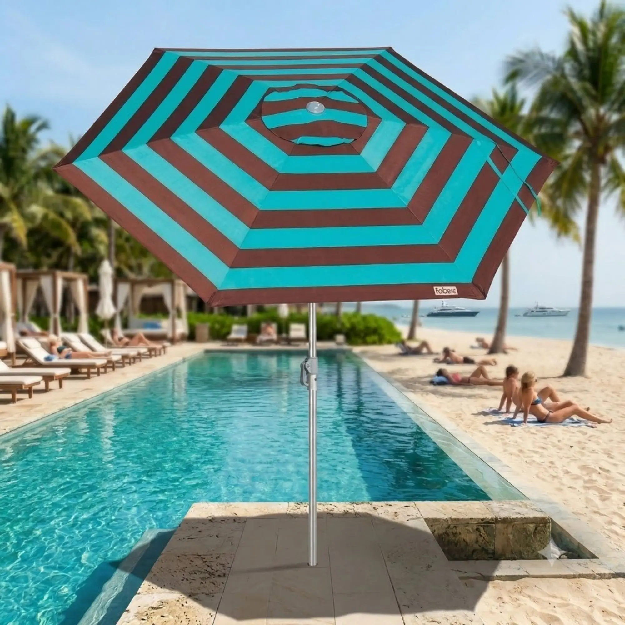 Guarda-sol ombrelone Malibu Tobee em destaque à beira da piscina com uma praia paradisíaca ao fundo.