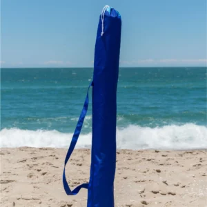 Capa protetora azul com alça para transporte do guarda-sol Ombrelone Malibu Beach da marca TOBEE fincada na areia da praia.