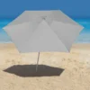 Guarda-sol de praia Malibu Tobee cinza aberto na areia projetando sombra com o mar ao fundo.