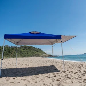 Visão frontal da Tenda Gazebo Tobee na praia com prolongamento de aba para a lateral direita, expandindo a área útil da Tenda Gazebo Flex 3 X 3m Dobrável Em Alumínio Uv50+ Tobee.
