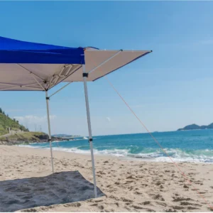Lateral da Tenda Gazebo Tobee montada na praia com corda tensionada, mostrando a estrutura resistente da Tenda Gazebo Flex 3 X 3m Dobrável Em Alumínio Uv50+ Tobee.